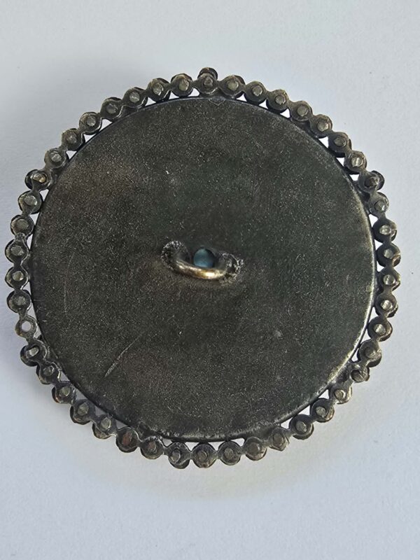 e58d1770-2972-4a1c-9b3a-1a8e1e34c3fb Cut Steel Over Blue Glass Button
